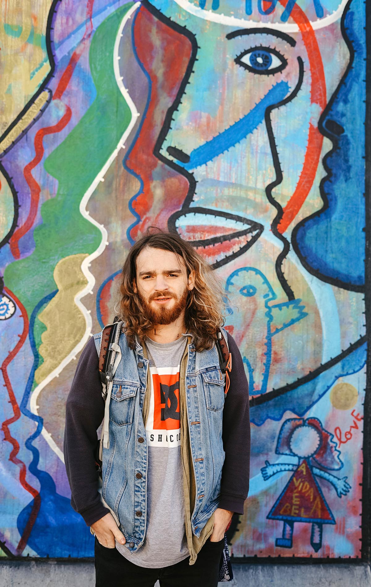 en man står framför en vägg med grafitti